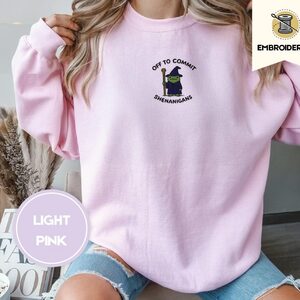 Person wearing a light pink Wizard Frog Embroidered Sweatshirt