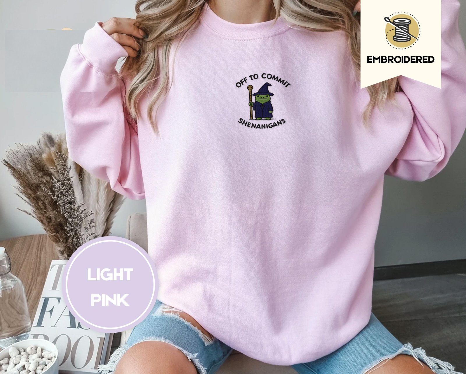 Person wearing a light pink Wizard Frog Embroidered Sweatshirt