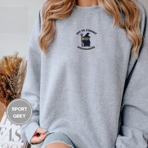 Person wearing a sport grey Wizard Frog Embroidered Sweatshirt