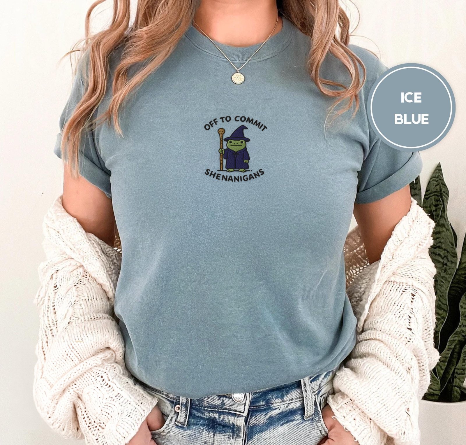 Person wearing an ice blue Wizard Frog Shenanigans Embroidered T-Shirt