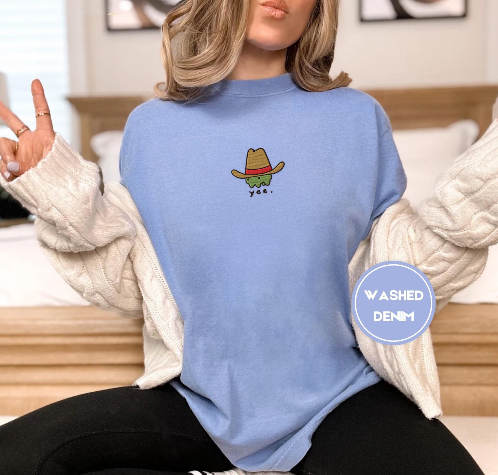 Person wearing a washed denim Yee Cowboy Frog Embroidered T-Shirt
